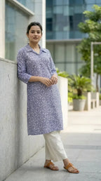 Woman wearing blue floral print kurta and cream pants from Karchobi, standing outdoors