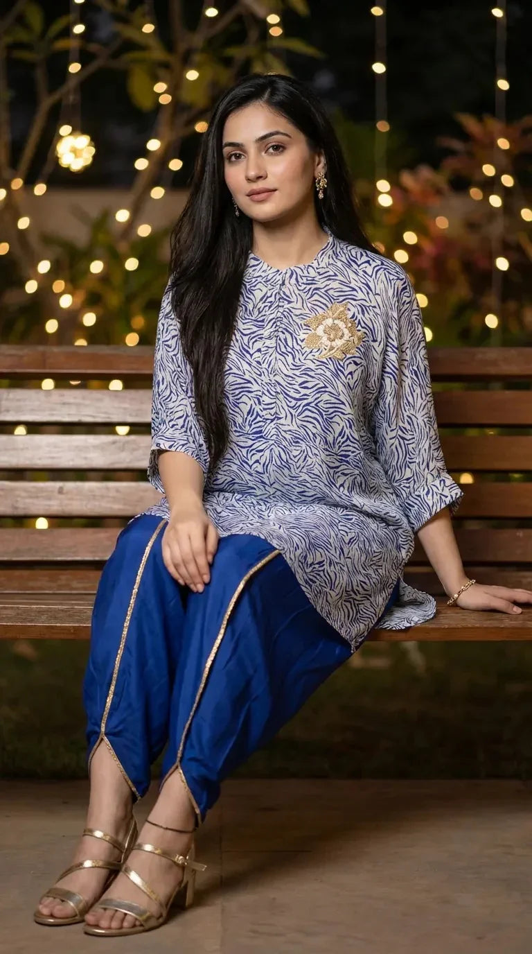 Woman in blue and white abstract print kaftan shirt with blue dhoti pants, sitting on a bench, Karchobi women's fashion
