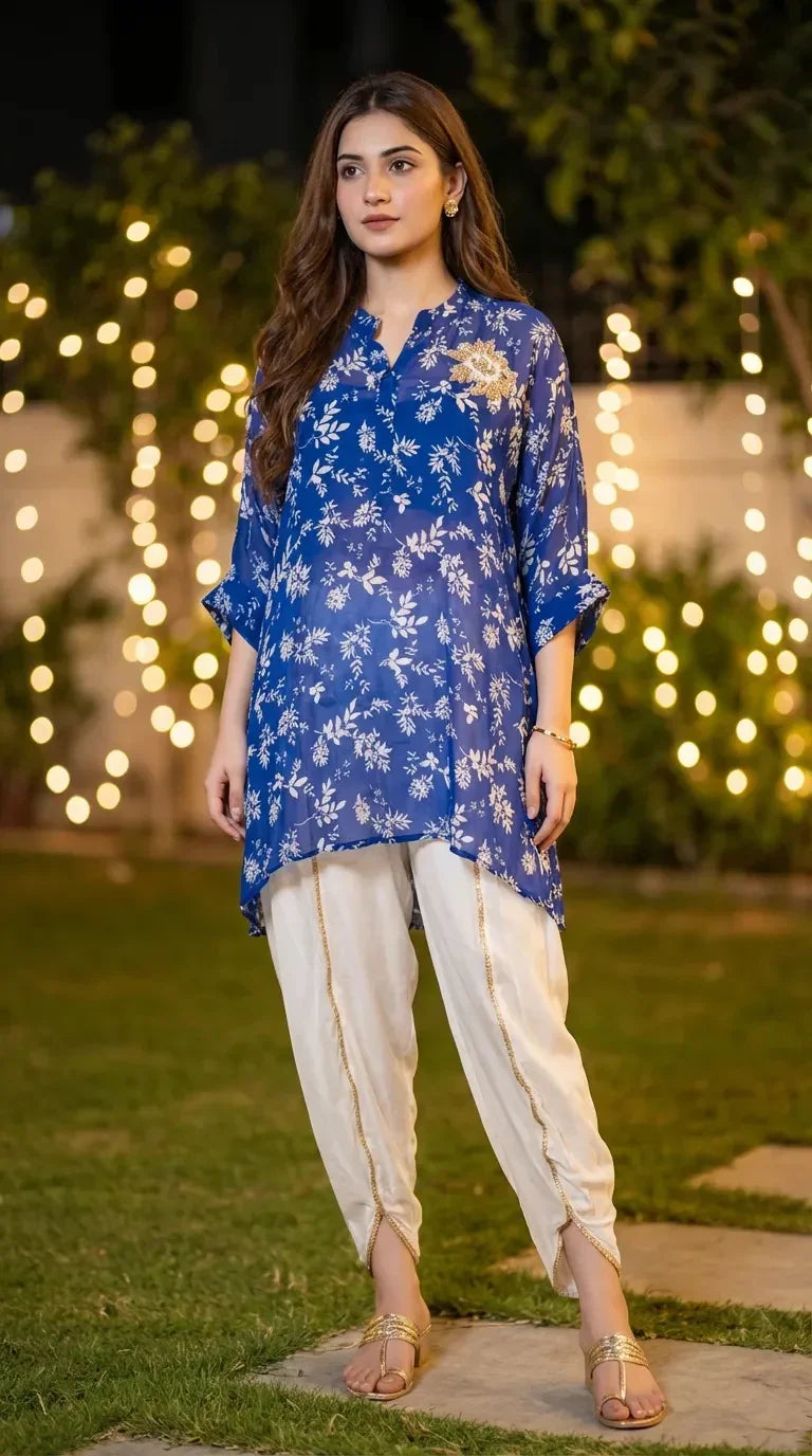 Woman in blue floral print kaftan shirt and white dhoti set by Karchobi, evening garden backdrop