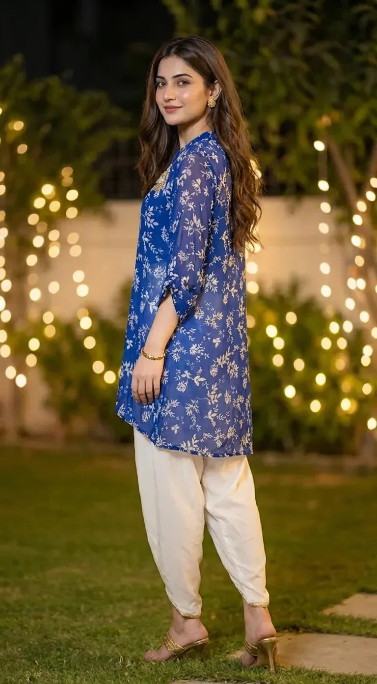 Woman in a blue floral Karchobi kaftan shirt with white dhoti pants, posing outdoors
