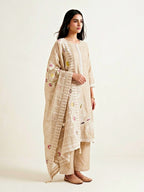 Beige chanderi cotton suit set with paisley embroidery, lace details, and matching kurta, pants, and dupatta by Karchobi.