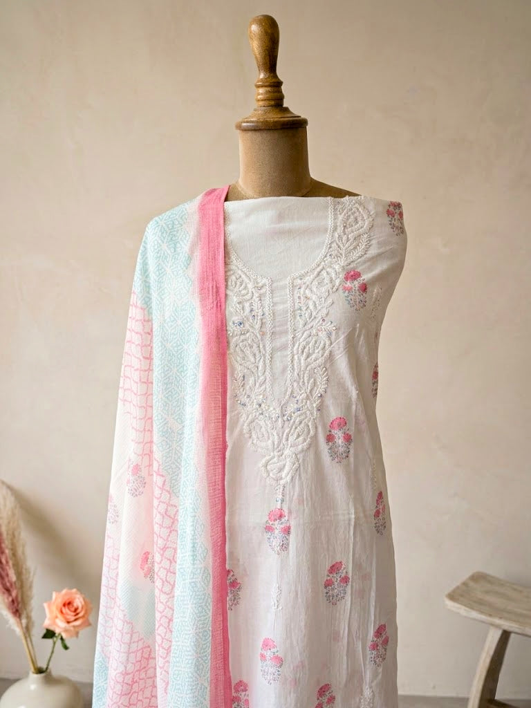 White cotton block print unstitched suit set with floral design, includes kurta, pants, and dupatta for women.
