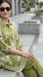 Woman in green printed kaftan shirt and pants co-ord set, sitting outdoors, Karchobi fashion