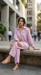 Woman wearing Karchobi light lilac textured shirt co-ord set with butterfly motif, sitting outdoors.