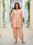 Light peach orange Karchobi Afghani salwar co-ord set featuring a cotton-linen kurta and matching trousers.