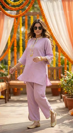 Woman wearing lilac textured kaftan shirt pant set from Karchobi, with scalloped lace details, at an outdoor event.
