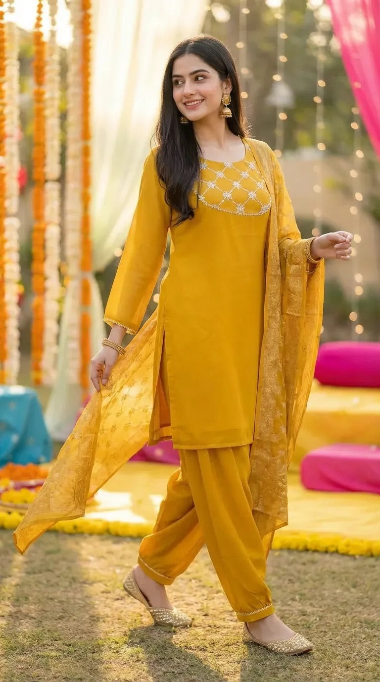 Woman wearing a mustard yellow kurta Afghani salwar set with gota lace, from Karchobi.