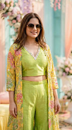 Woman wearing neon green raw silk crop top and sharara pants with yellow sequin embroidered jacket, Karchobi occasion wear.