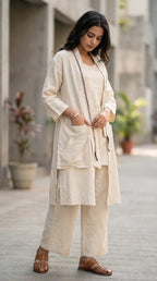 Woman wearing Karchobi off-white three-piece co-ord set with long jacket and wide-leg pants