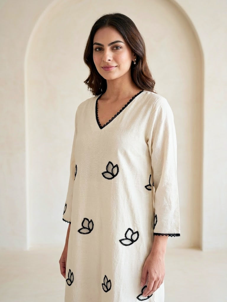 Off-White Karchobi embroidered kurta dress with black floral appliqué and intricate embroidery, stylish long ethnic wear.