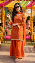 Woman wearing Karchobi orange floral sequin embroidered kurta sharara lace set at outdoor event