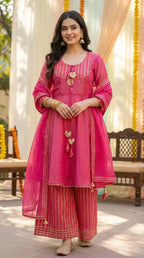 Woman in a pink peplum sharara set with gold gota lace, festive wear from Karchobi.