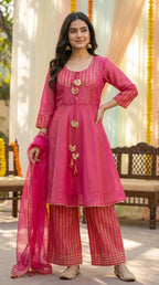 Woman in pink peplum sharara set with gotta laces, from Karchobi, outdoor festive setting