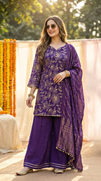 Woman wearing purple floral sequin embroidered kurta sharara dupatta set outdoors, Karchobi fashion