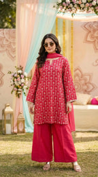 Woman in rani pink kurta sharara set with gota embroidery by Karchobi, outdoor floral decor