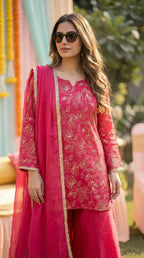 Woman in rani pink floral sequin zari embroidery kurta sharara set by Karchobi outdoors