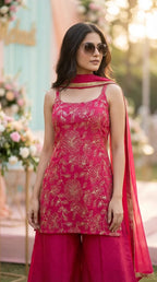 Woman wearing a rani pink floral sequin zari embroidery sleeveless kurta sharara set by Karchobi