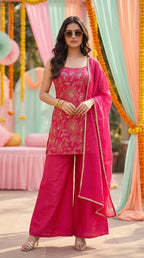Woman in a vibrant rani pink floral sequin zari sleeveless kurta sharara set by Karchobi