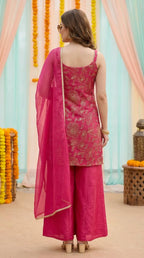Woman wearing a rani pink floral sequin zari embroidered sleeveless kurta sharara set from Karchobi