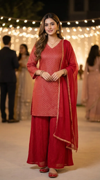 Woman in a red gold zari kurta with crushed sharara set from Karchobi, festive background