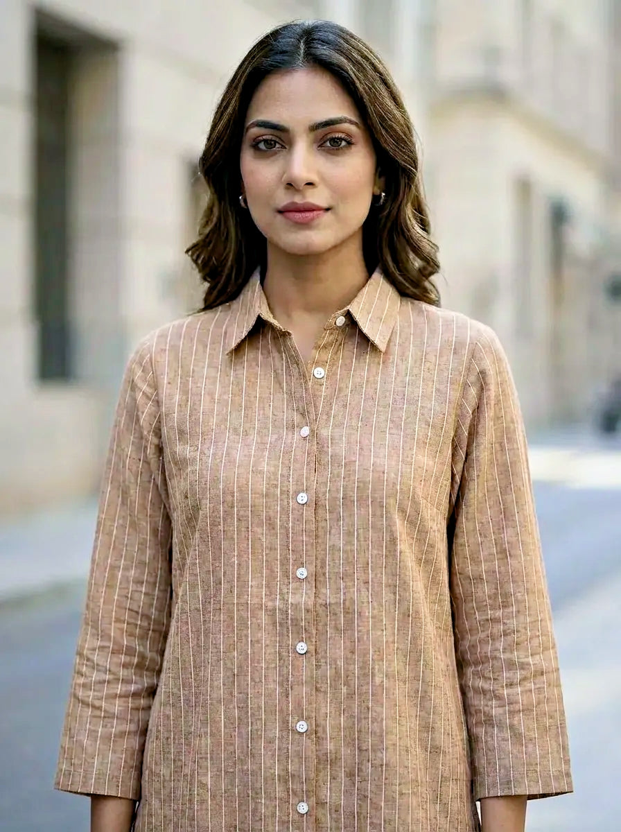 Woman wearing a tan beige pin striped coord set standing outdoors with blurred background