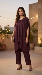 Woman modeling Karchobi wine shimmer cowl cut co-ord set, evening terrace setting
