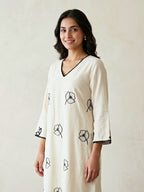 Off-white and black kurta dress by Karchobi featuring floral embroidered motifs and appliqué work, long and elegant style.