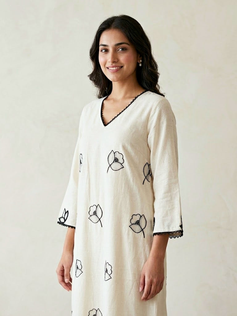 Off-white and black kurta dress by Karchobi featuring floral embroidered motifs and appliqué work, long and elegant style.