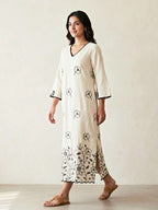 Off-white and black kurta dress with floral embroidered motifs by Karchobi, featuring intricate applique embroidery and a long, elegant design.